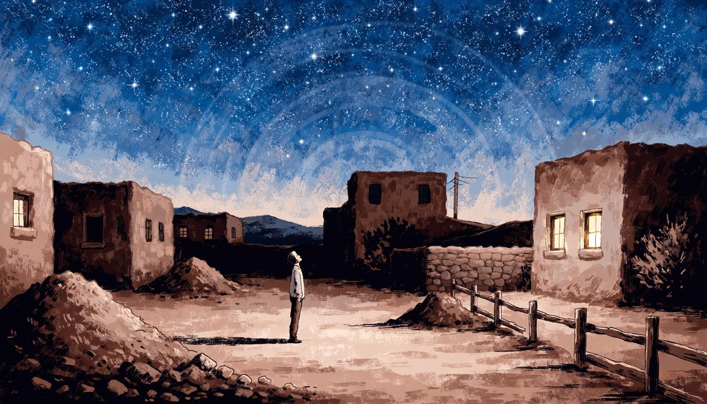A lone figure looks up at a star-filled sky over adobe buildings in Taos, New Mexico